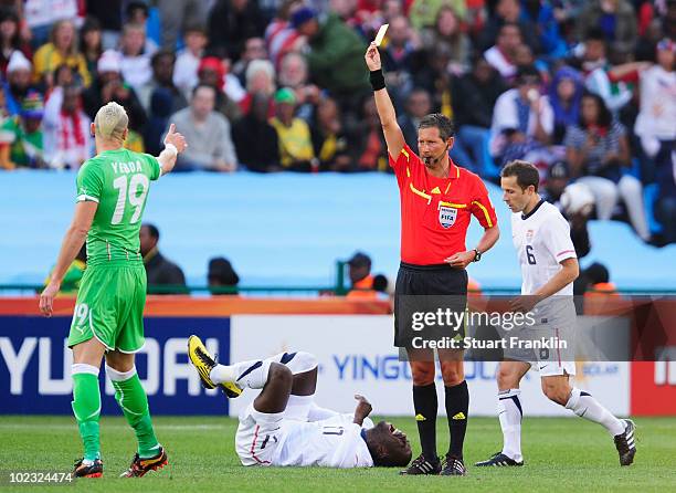 Hassan Yebda of Algeria receives a yellow card from referee Frank de Bleeckere after a tackle on Jozy Altidore of the United States during the 2010...