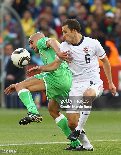 Rafik Djebbour of Algeria and Steve Cherundolo of the United States battle for the ball during the 2010 FIFA World Cup South Africa Group C match...