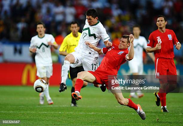 James Milner of England tackles Andraz Kirm of Slovenia during the 2010 FIFA World Cup South Africa Group C match between Slovenia and England at the...