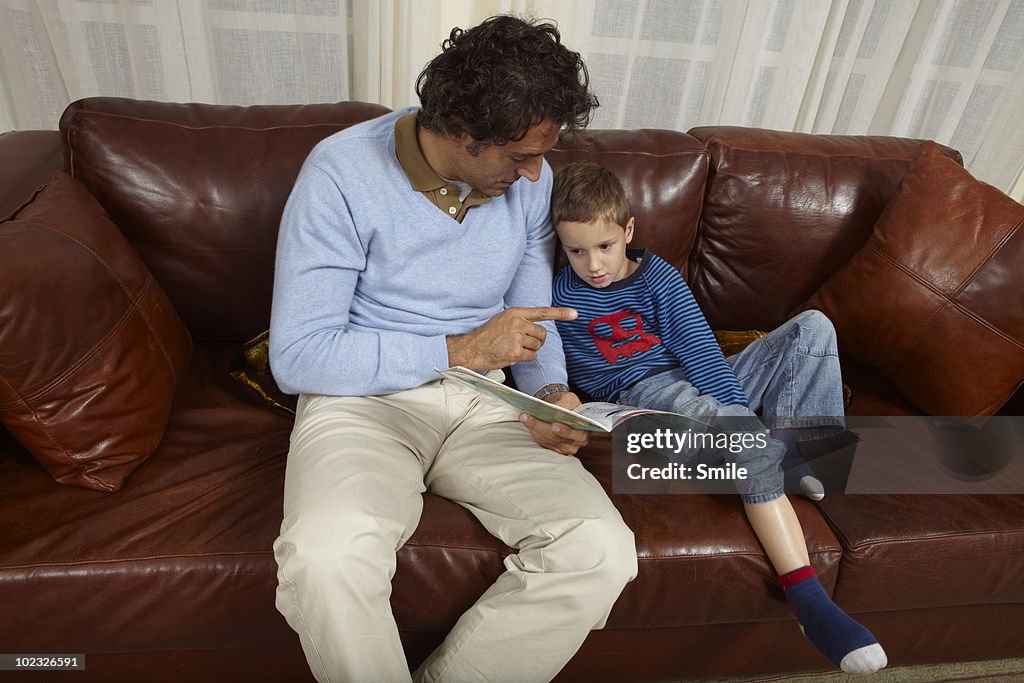 Father teaching his son a lesson from a book