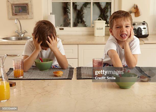 twin boys unhappy with their breakfast - picky eater stockfoto's en -beelden