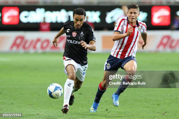 Jose Godínez of Chivas fights for the ball with Leobardo López of Necaxa during the 6th round match between Chivas and Necaxa as part of the Torneo...