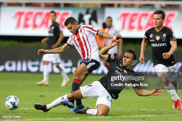 Orbelin Pineda of Chivas fights for the ball with Leobardo López of Necaxa during the 6th round match between Chivas and Necaxa as part of the Torneo...