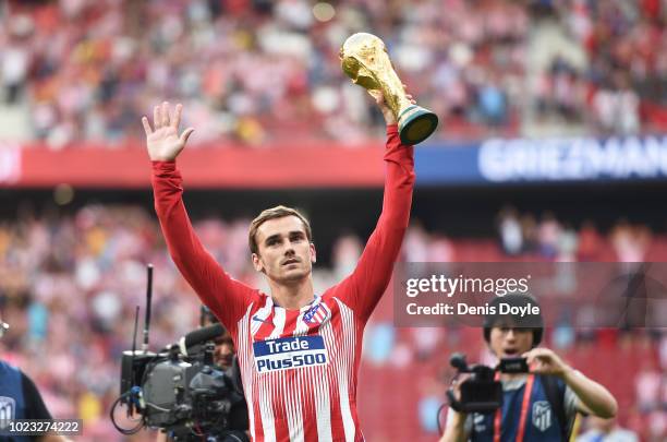 Antoine Greizmann of Club Atletico de Madrid holds up the FIFA World Cup trophy before the La Liga match between Club Atletico de Madrid and Rayo...