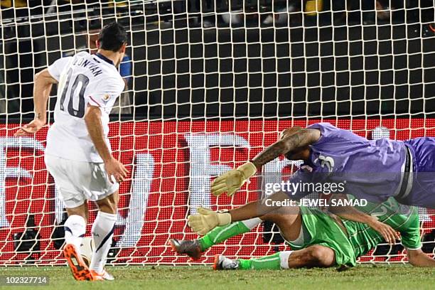 Midfielder Landon Donovan scores a goal past Algeria's goalkeeper M'bolhi Rais Ouheb during the Group C first round 2010 World Cup football match US...