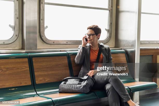 businesswoman on a ferry on cell phone - commuter ferry stock pictures, royalty-free photos & images