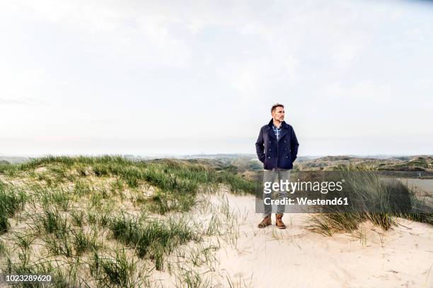 man standing in dune landscape - mann frontal ganzkörper jacket stock-fotos und bilder