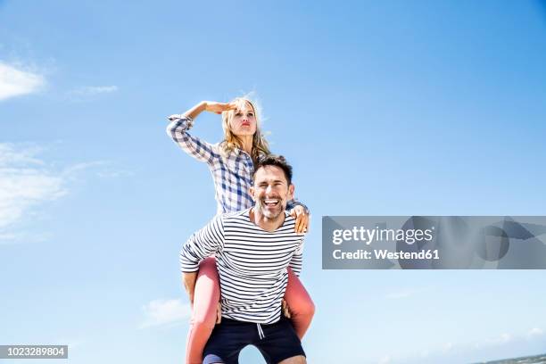 happy playful couple outdoors - portare a cavalluccio foto e immagini stock