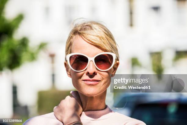 portrait of blond woman wearing sunglasses - zonnebril stockfoto's en -beelden