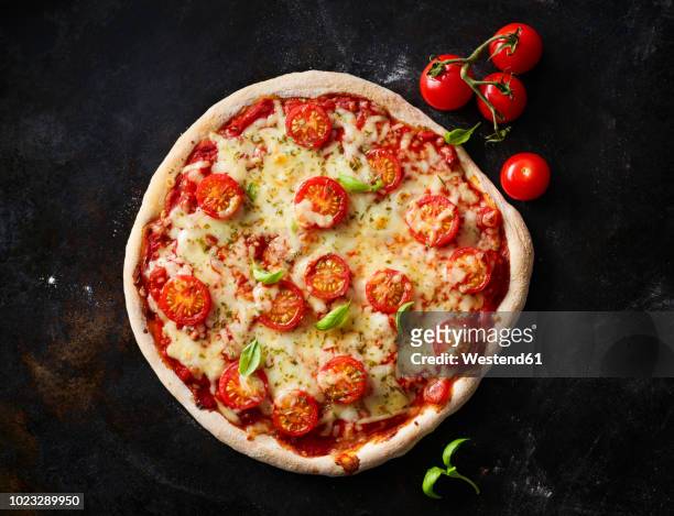 pizza margherita and cherry tomatoes on dark ground - cherry tomatoes stock-fotos und bilder