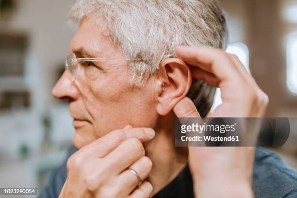 senior man with hearing aid - ear stockfoto's en -beelden