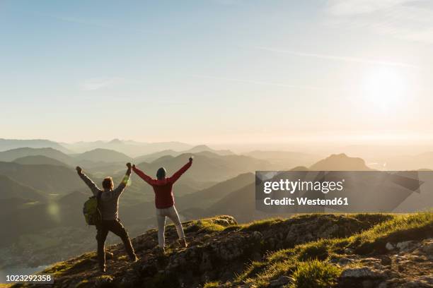 austria, salzkammergut, cheering couple reaching mountain summit - couple voyage sport photos et images de collection