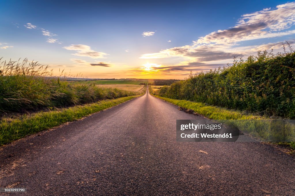 UK, Scotland, East Lothian, empty country road at sunset