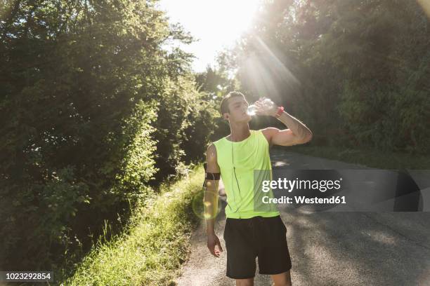 jogger in the park drinking water - running refreshment stock pictures, royalty-free photos & images