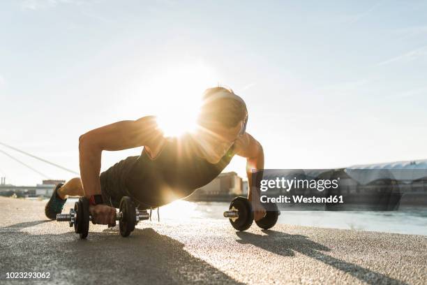 fit athlete doing push ups at the river - flexiones fotografías e imágenes de stock
