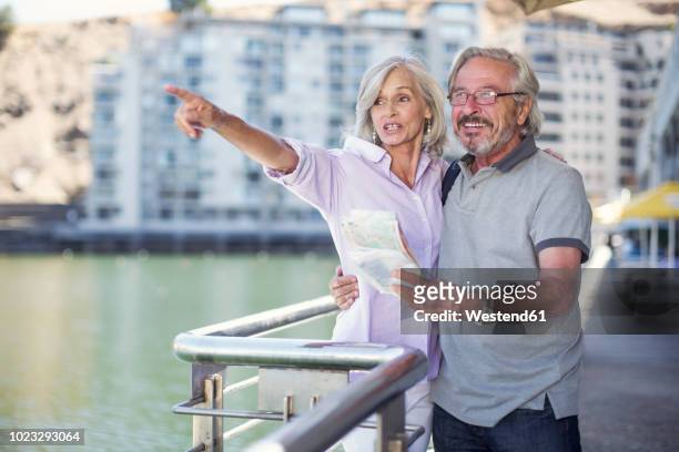 senior couple taking a city break, holding map - city map with points of interest stock pictures, royalty-free photos & images