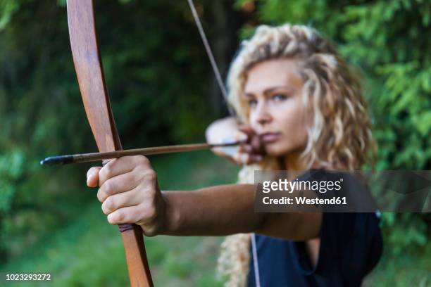 archeress aiming with her bow, close-up - boog pijl en boog stockfoto's en -beelden
