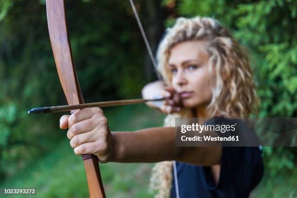 archeress aiming with her bow, close-up - bow and arrow stock pictures, royalty-free photos & images