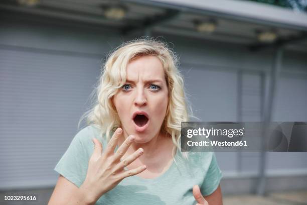 portrait of shocked woman outdoors - überraschung stock-fotos und bilder