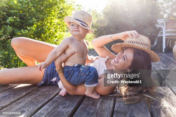 mother and baby boy having fun on terrace - baby sommer stockfoto's en -beelden