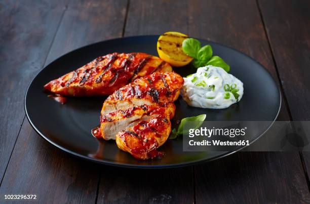 grilled chicken breast fillet with sour cream on plate - hühnchenbrust stock-fotos und bilder
