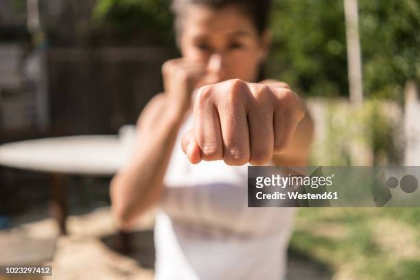 fist of selfdefending young woman, close-up - verteidigen stock-fotos und bilder