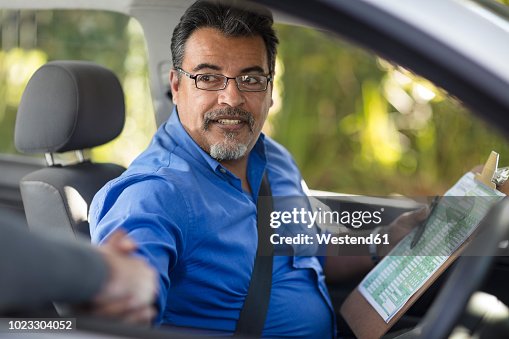 Driving instructor shaking hands with learner driver Driving instructor shaking hands with learner driver