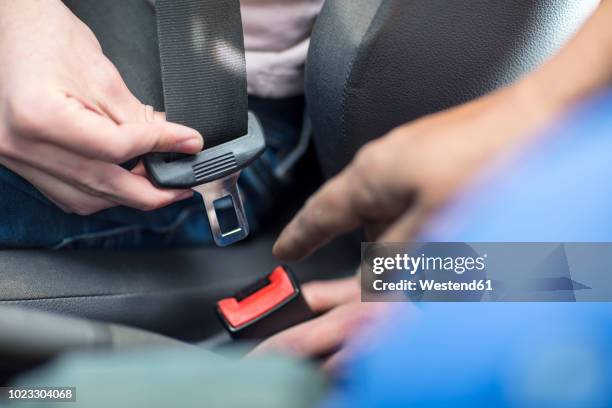 male hands in car fastening safety belt - sicherheitsgurt teil eines fahrzeugs stock-fotos und bilder