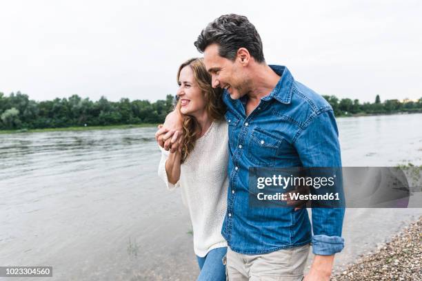 happy couple walking at the riverside - man 30s stock pictures, royalty-free photos & images