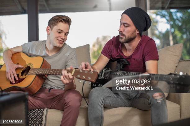 musician teaching student how to play guitar - teen musician stock pictures, royalty-free photos & images