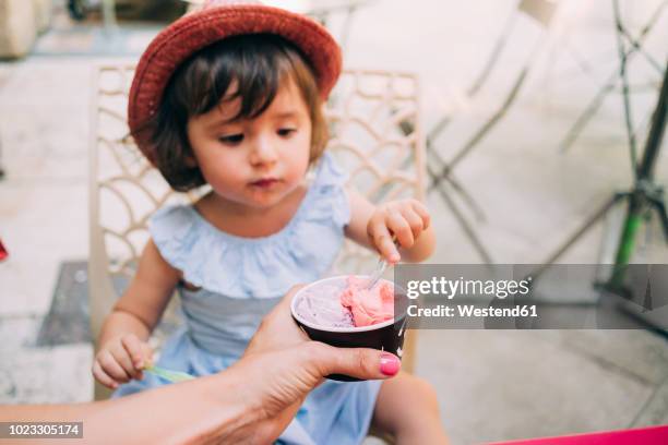 cute toddler girl eating an ice cream held by her mother - baby cup fotografías e imágenes de stock