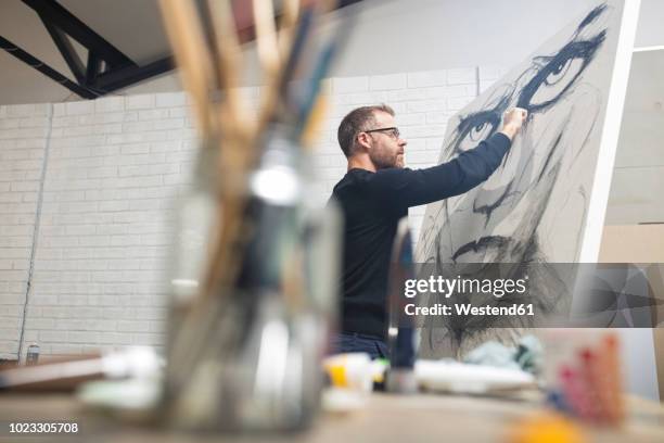 man checking drawing in studio - künstler stock-fotos und bilder