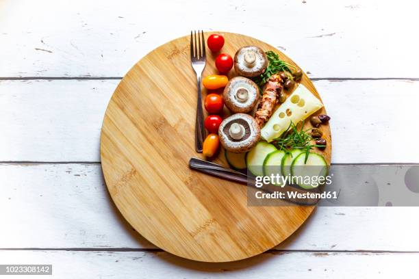 vegetables on round chopping board, symbol for intermittent fasting - fasting activity stock-fotos und bilder