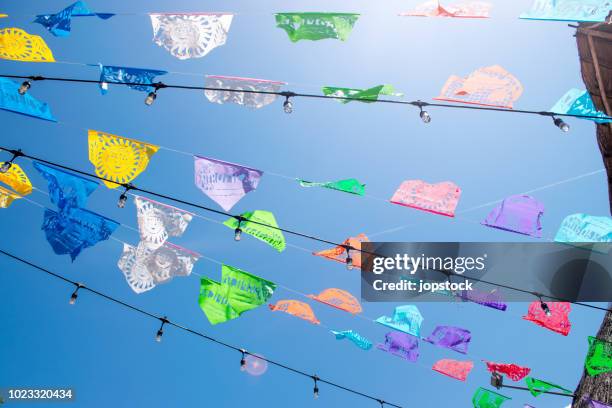 colorful pennant flags for party decoration against sky - mexican bunting stock pictures, royalty-free photos & images