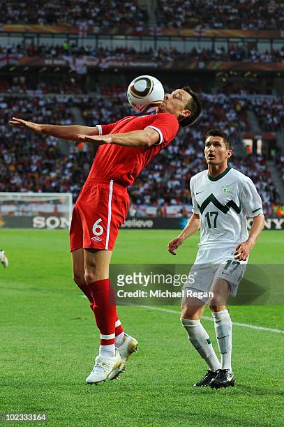 John Terry of England controls the ball as Andraz Kirm of Slovenia looks on during the 2010 FIFA World Cup South Africa Group C match between...