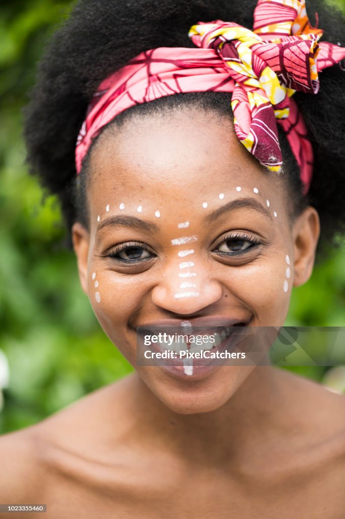 Portrait young African woman with painted traditional make up smiling to camera
