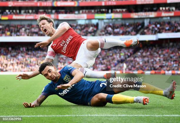 Ryan Fredericks of West Ham United and Nacho Monreal of Arsenal clash during the Premier League match between Arsenal FC and West Ham United at...