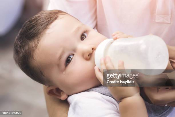 dad feeding his baby boy with milk bottle - mother son milk imagens e fotografias de stock