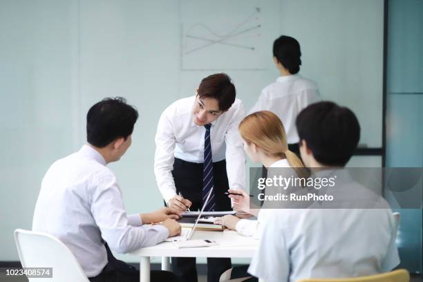 business people reviewing paperwork in office - japan training session stock pictures, royalty-free photos & images