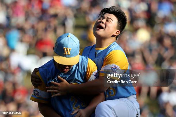 Starting pitcher Aukai Kea of the West Region from Hawaii celebrates getting the final out with teammate Sean Yamaguchi during their 3-0 win over the...