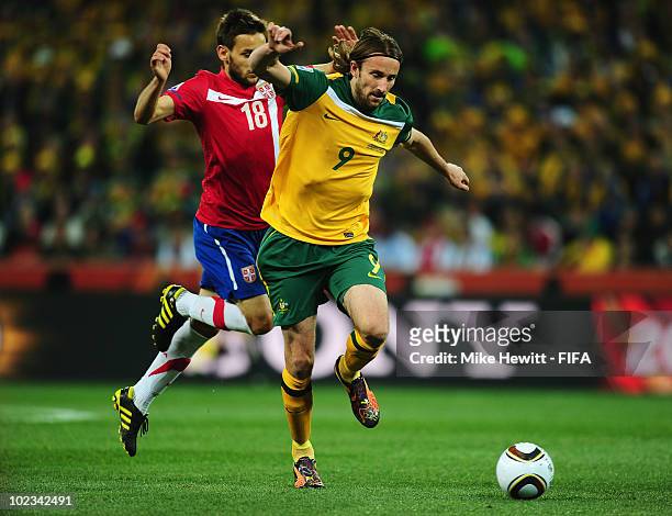 Milos Ninkovic of Serbia challenges Joshua Kennedy of Australia during the 2010 FIFA World Cup South Africa Group D match between Australia and...
