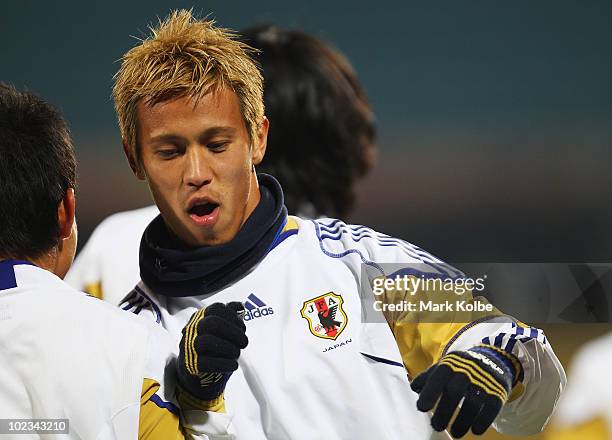 Keisuke Honda bumps into a team mate at a Japan training session during the FIFA 2010 World Cup at Royal Bafokeng Stadium on June 23, 2010 in...