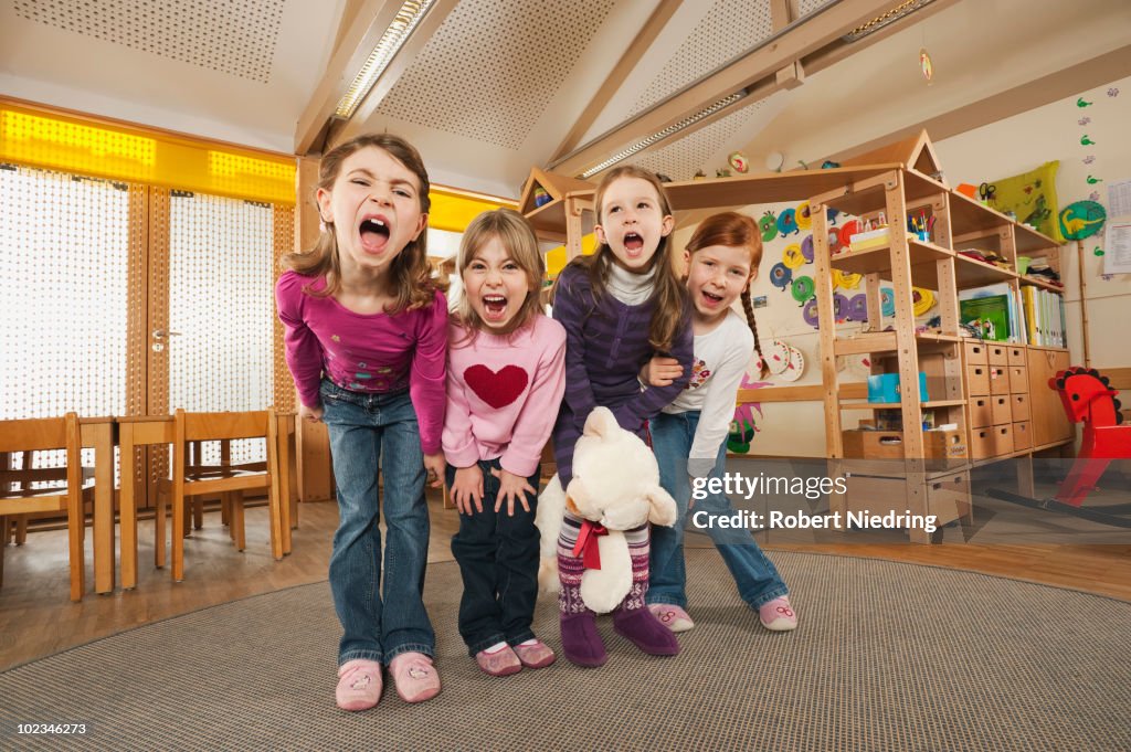 Germany, Children in nursery standing side by side screaming, portrait