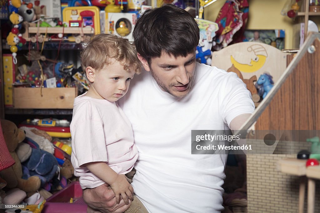 Germany, Berlin, Father and son (3-4) in toy store, portrait