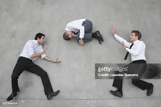 businessmen balancing on rope,playing with collegue - position du foetus photos et images de collection