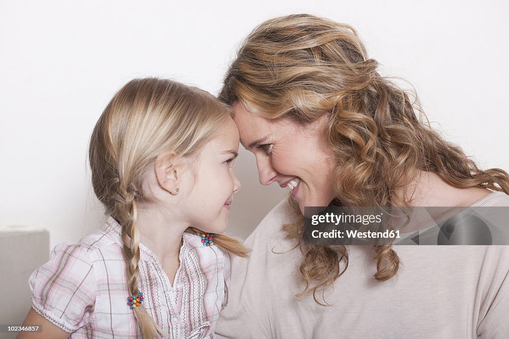 Germany, Cologne, Mother and daughter (4-5) head to head, portrait, close-up