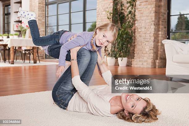 germany, cologne, mother playing with daughter (4-5) - allongé sur le dos photos et images de collection