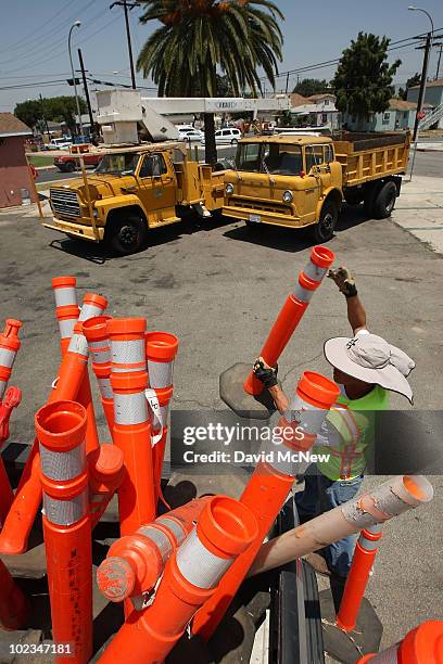 Ernest Beas, an employee of ICE Engineering, picks up traffic control posts after completing a speed bump construction project that was contracted...