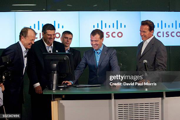 Russian President Dmitry Medvedev works on the computer as Cisco Chairman and CEO John Chambers , Jim Grubb , Chief Demonstration Officer, and...