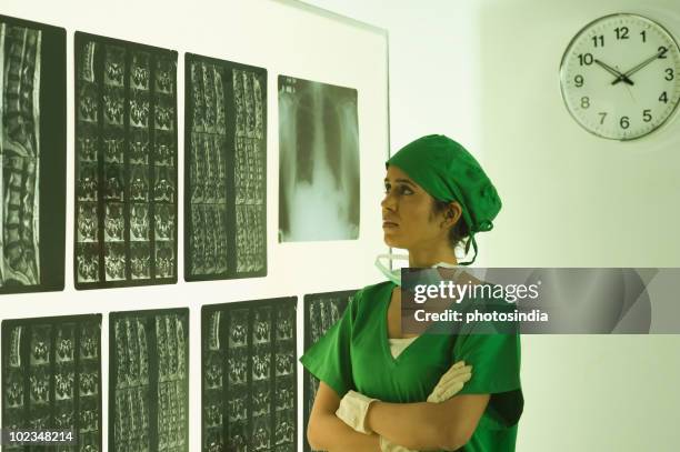 female surgeon examining an x-ray report - surgical cap stock pictures, royalty-free photos & images